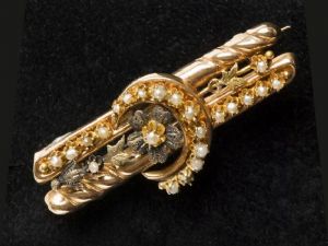 Gold brooch with pearls featuring a moon and star